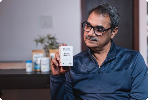 A User with Black Seed Oil in his hand for product review